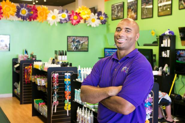 Anthony Simmons, a former NFL linebacker, poses for a photo in his Henderson based business Sharkey's Cuts for Kids, Monday July 15, 2013.